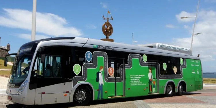 Imagem de um ônibus movido a biometano estacionado no asfalto.