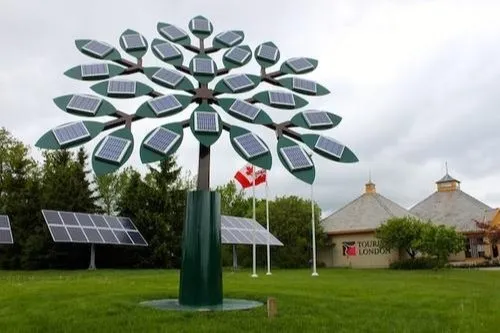 Uma árvore artificialmente construída de metal verde com placas fotovoltaicas que é um exemplo de Árvores solares.