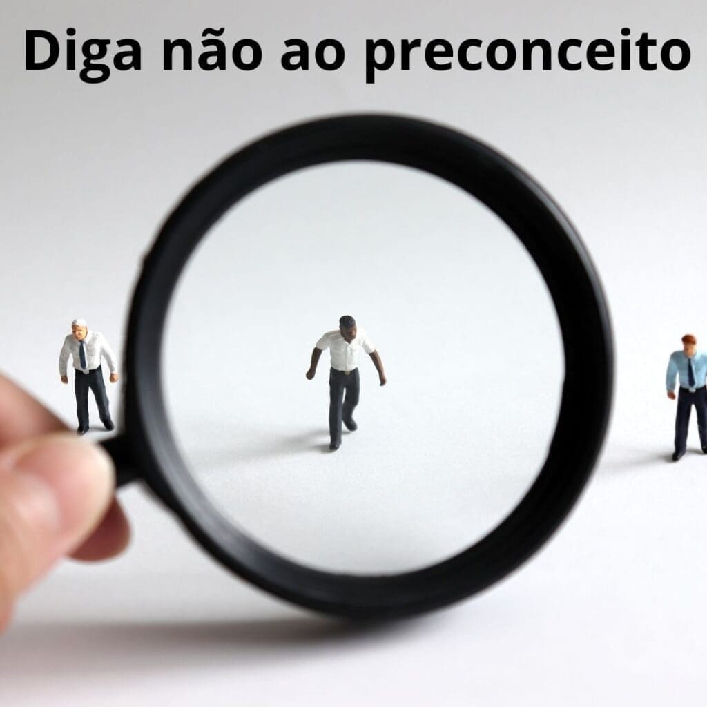 uma mão com uma lupa analisa um homem negro ao centro da imagem, em cima está escrito: diga não ao preconceito.