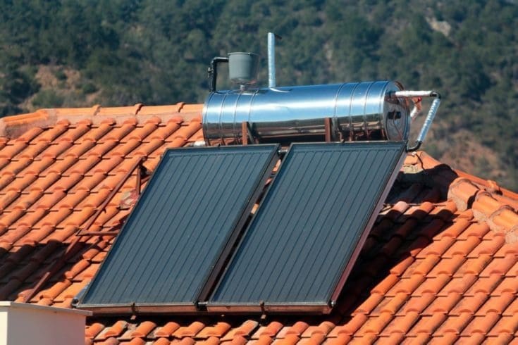 Um telhado laranja que tem um painel de Aquecimento Solar da Água.