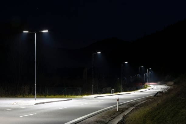 Céu noturno ao fundo com Iluminação Pública a Laser nos postes de uma rodovia.