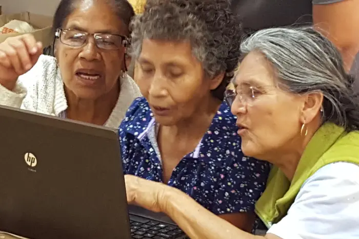 segregação digital pode acontecer com pessoas mais velhas, três idosas interagindo com a tela de um notebook.