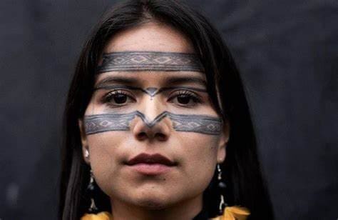 Helena Gualinga com o rosto pintado com linhas indígenas na testa e bochechas