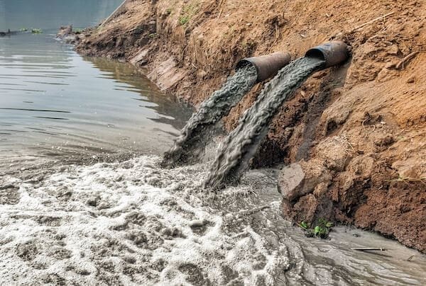 Saida de esgoto mostra poluição dos resíduos produzidos pelos impactos das indústrias na água