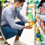 Um rapaz em um supermercado escolhe produtos baseado no consumo responsável